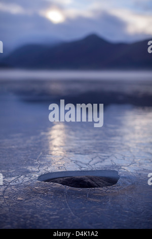 Trou dans couche de glace sur rural lake Banque D'Images