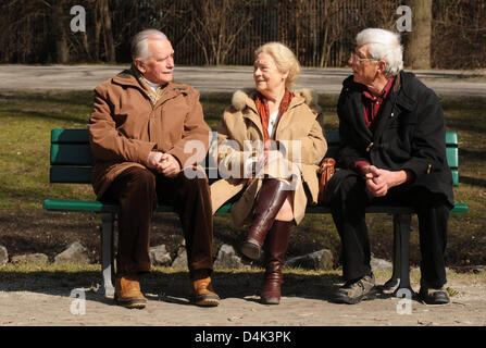 Les retraités Theodor Ziegler (L-R), Elisabeth Ziegler et Horst Hoerhager s'asseoir au soleil sur un banc de parc dans le Jardin Anglais de Munich, Allemagne, 18 mars 2009. Ils jouissent de la belle journée de printemps. Photo : Felix Hoerhager Banque D'Images