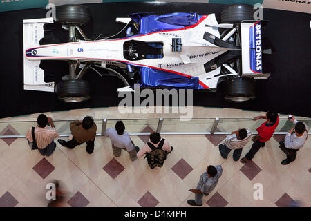 Les visiteurs d'un centre commercial oeil un exposé de Formule 1 BMW-Sauber race car dans Kuala Lumpur, Malayisa, 31 mars 2009. Le Grand Prix de Malaisie de Formule 1 aura lieu au circuit de Sepang, près de Kuala Lumpur le 05 avril 2009. Photo : JENS BUETTNER Banque D'Images