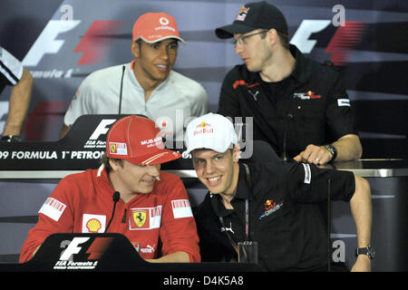 Pilote de formule 1 finlandais Kimi Raikkonen (bas) de l'Allemand parle de Ferrari pilote de Formule 1 Sebastian Vettel (bas) R de Red Bull en tant que pilote de Formule 1 britannique Lewis Hamilton (L) haut de McLaren Mercedes parle au Français pilote de Formule 1 Sébastien Bourdais (R) haut de la Toro Rosso lors d'une conférence de presse au circuit de Sepang à la périphérie de Kuala Lumpur, Malaisie, 02 avril Banque D'Images