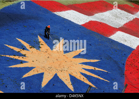 Un homme travaille sur un drapeau malaisien peint sur l'herbe au cours de la première formation au circuit de Sepang à la périphérie de Kuala Lumpur, Malaisie, 03 avril 2009. 2009 Le Grand Prix de Malaisie de Formule 1 aura lieu le dimanche 05 avril. Photo : Jens Buettner Banque D'Images