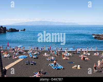 La plage de Playa La Arena une ville de villégiature sur la côte ouest de Tenerife. Vues, de lave noire de haute mer et sur La Gomera Banque D'Images