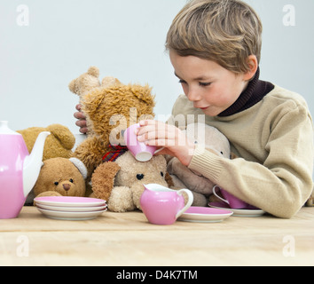 Boy having tea party avec nounours Banque D'Images