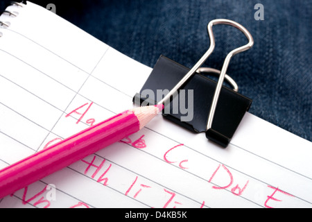 L'écriture l'alphabet sur papier a avec un crayon de couleur rose Banque D'Images