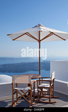 L'image d'un ensemble de table et chaises sur un balcon donnant sur la caldeira. Santorin, Grèce. Banque D'Images