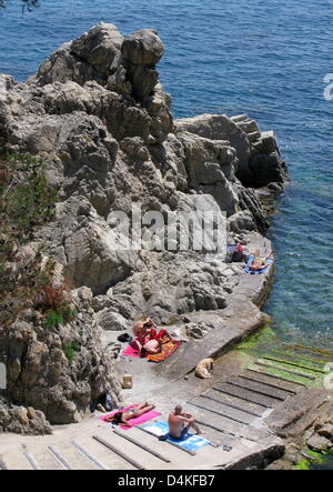 Les touristes se trouvent dans le soleil sur la côte rocheuse près de la ville de Calella de Palafrugell sur la Costa Brava, Espagne, 01 juin 2009. Photo : Roland Holschneider Banque D'Images