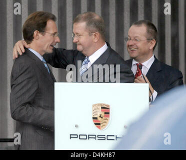 Nouveau PDG de Porsche AG, Michael Macht (L) hugs Wendelin Wiedeking PDG sortant (C) à l'avant du membre du conseil pour les finances, Holger Haerter, lors d'une réunion à Stuttgart-Zuffenhausen, œuvres de l'Allemagne, 23 juillet 2009. Wiedeking a démissionné de son poste après 16 ans, ouvrant la voie pour un avenir commun de l'automobile Porsche et Volkswagen. Photo : Ronald WITTEK Banque D'Images