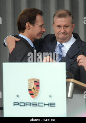 Les PDG de Porsche AG, Michael Macht (L) hugs Wendelin Wiedeking PDG sortant (C) lors d'une réunion à Stuttgart-Zuffenhausen travaille, l'Allemagne, 23 juillet 2009. Wiedeking a démissionné de son poste après 16 ans, ouvrant la voie pour un avenir commun de l'automobile Porsche et Volkswagen. Photo : Uli Deck Banque D'Images