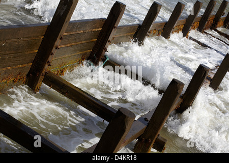 Vagues sur les bois épis à Walcott Écart sur la côte de Norfolk, UK Banque D'Images