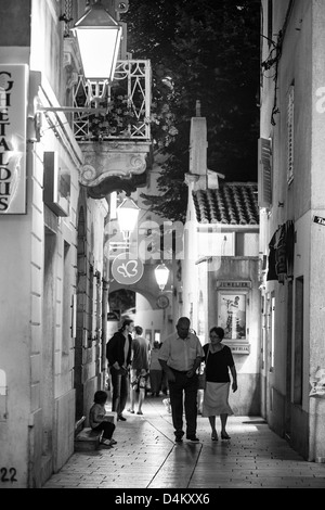 L'âge moyen d'un couple en train de marcher dans les rues de la ville sur l'île croate de Krk Krk. Krk est une destination touristique très populaire. Banque D'Images