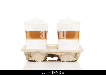 Deux gobelets en plastique avec latte macchiato pour aller dans un porte-gobelet sur fond blanc Banque D'Images