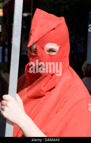 Une jeune fille portant le capot d'un bourreau médiéval, tenant un panneau publicitaire, annonçant un musée local de chambre de torture, une attraction touristique à Viru Banque D'Images