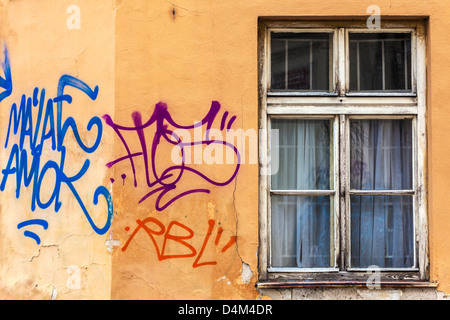 Un graffiti sur une paroi par une vieille fenêtre en décomposition dans une petite rue dans la vieille ville de Prague, Praha, République Tchèque Banque D'Images