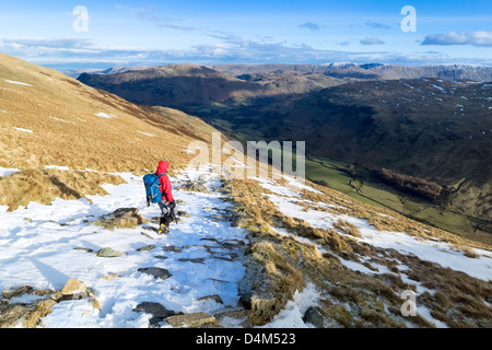 Un randonneur en ordre décroissant du trou dans le mur vers Grisedale Beck dans le Lake District. Banque D'Images