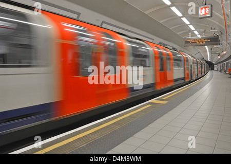 Plate-forme vide sur la station de métro de Londres avec le flou du tube Central Line train au départ Shepherds Bush West London England UK Banque D'Images