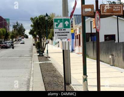 Un parcours d'évacuation tsunami, via de evacuacion, signer au bas d'une rue de maisons en tôle ondulée peintes de couleurs vives Banque D'Images