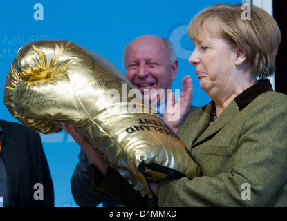 Grimmen, Allemagne. 16 mars 2013. La chancelière allemande, Angela Merkel, est titulaire d'un gant de boxe d'or géant au cours de la réunion les représentants du Parti chrétien démocrate, la CDU en Grimmen, Allemagne, 16 mars 2013. Dans le dos, membre du Bundestag CDU Eckhardt Rehberg (R) est vu. Merkel a été élu à l'unanimité le candidat de tête de Mecklembourg Poméranie CDU. Elle a reçu l'ensemble des 113 voix. Photo : STEFAN SAUER/Alamy Live News Banque D'Images