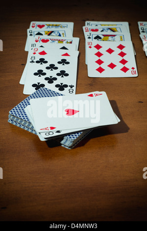 Aménagé au milieu de cartes jeu de Solitaire sur table en bois. Banque D'Images