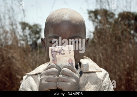 Un jeune garçon tenant un kwacha 500 Note sur la Great North Road, au nord de Lusaka en Zambie , Province centrale. Banque D'Images