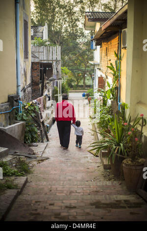 12 mars 2013 - Luang Prabang, Laos - Un homme et son fils descendre une petite rue à Luang Prabang, Laos. Luang Prabang a plus de 30 temples et est un UNESCO World Heritage Site. C'est l'attraction touristique la plus visitée du Laos. (Crédit Image : © Jack Kurtz/ZUMAPRESS.com) Banque D'Images