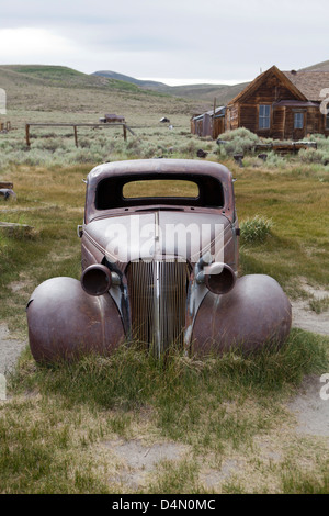 Vieille voiture rouillée entouré de maisons abandonnées Banque D'Images