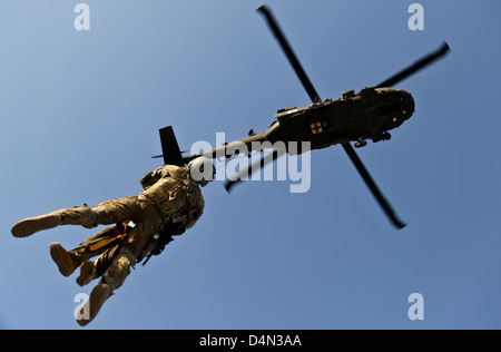Un vol US Army medic et un commando de l'Armée nationale afghane sont hissés à l'armée américaine un UH-60 Black Hawk lors de l'extraction de la formation le 4 mars 2013 dans Bihsud district, province de Nangarhar, en Afghanistan. Les commandos de l'ANA et les forces de la coalition a mené la formation en vue d'extractions de dommages possibles au cours d'opérations de combat. Banque D'Images