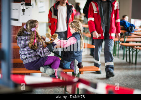 Jasmin (L-5) et Leyla (7) jouer avec deux nounours dans le centre dans l'evacutaion Eichendorff-Gymnasium à Bamberg, Allemagne, 17 mars 2013. Plusieurs milliers de personnes ont dû quitter leur foyer pour le désarmement des deux bombes aériennes de la Seconde Guerre mondiale. Photo : David Ebener/Alamy Live News Banque D'Images