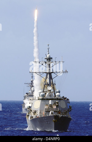 Lance-missiles le destroyer USS Benfold avant les manœuvres de missiles guidés USS cruiser comme il Chosin tire un missile sol-air au cours de l'exercice le 11 juillet 2010 au large de la côte d'Hawaï . Banque D'Images