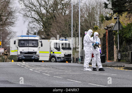 17/03/2013, Newtownabbey, Irlande du Nord. Deux officiers habillés en costumes judiciaires examiner un périphérique trouvé sur le sol d'une chapelle catholique romaine peu avant 9h. Banque D'Images