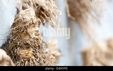 Sculpture en bois du vieil homme en fond bleu. La figure de la main en souriant. Beau produit sculpté de naturel mate Banque D'Images