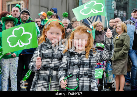 Belfast, Irlande du Nord. 17 mars, 2013. Deux jeunes filles sont parmi les milliers de personnes qui jalonnaient les rues de Belfast pour regarder l'Assemblée Saint Patrick's Day Parade à Belfast. Banque D'Images