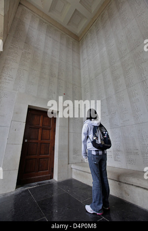 Une jeune femme regardant les noms gravés dans la pierre à la porte de memin Ypres (Ieper). Banque D'Images