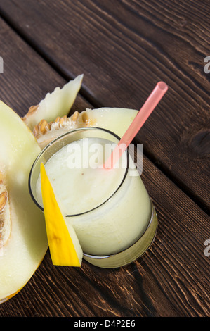 Fait frais Jus de miellat avec des morceaux de fruit sur fond de bois Banque D'Images