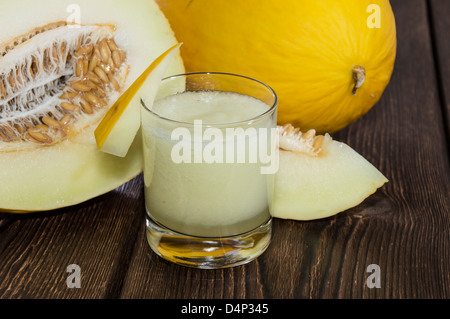 Fait frais Jus de miellat avec des morceaux de fruit sur fond de bois Banque D'Images