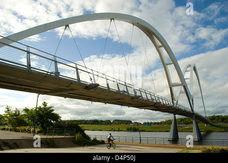 Un jeune homme chevauche son vélo sous le pont de l'infini, Stockton on Tees, Cleveland, UK Banque D'Images