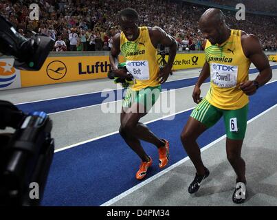 Jamaican Usain Bolt (L) célèbre sa victoire dans le men ?s 100m finale avec troisième placé Jamaican Asafa Powell lors du 12ème Championnat du monde d'athlétisme IAAF à Berlin, Allemagne, 16 août 2009. Bolt a établi un nouveau record du monde de 9,58 secondes. Photo : KAY NIETFELD Banque D'Images