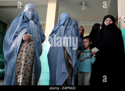 Les femmes afghanes tenir leurs cartes de vote pendant qu'ils attendent à un bureau de scrutin dans une mosquée de Kaboul, Afghanistan, le 20 août 2009. C'est la deuxième fois que quelque 12 millions d'Afghans sont admissibles à voter un nouveau président après la destruction du régime des talibans. Photo : Marcel Mettelsiefen Banque D'Images