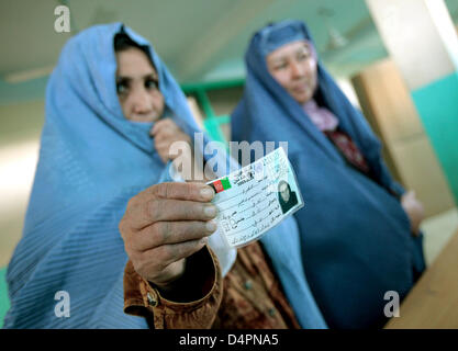 Les femmes afghanes tenir leurs cartes d'identité pendant l'attente à un bureau de scrutin dans une mosquée de Kaboul, Afghanistan, le 20 août 2009. C'est la deuxième fois que quelque 12 millions d'Afghans sont admissibles à voter un nouveau président après la destruction du régime des talibans. Photo : Marcel Mettelsiefen Banque D'Images