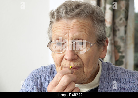 Femme âgée de prendre un comprimé (nitrofurantoin macrodantin antibiotiques) Banque D'Images