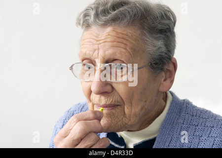 Femme âgée de prendre un comprimé (nitrofurantoin macrodantin antibiotiques) Banque D'Images