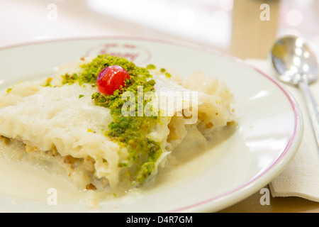 Gullac traditionnelle turque Ramadan dessert à base de pâte filo et lait sucré, servi avec crumble de pistache et complime Banque D'Images