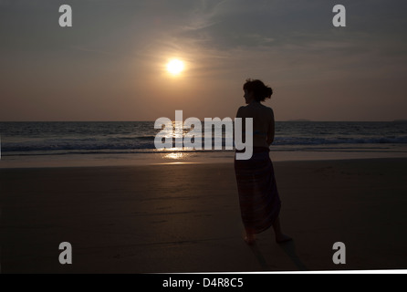 Situé sur Arossim Beach, Sud de Goa, Inde. Une femme donne sur la mer au coucher du soleil dans l'après-midi. Banque D'Images