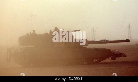 Un char de combat type M1-A1 Abrahams du 1er Bataillon du réservoir de la 1ère Division de Marines américains avances dans un long convoi de véhicules militaires, le 19 mars 2003, à partir de leur camp Coyote au Koweït à la frontière irakienne. Les soldats sont en attente, après l'expiration de l'ultimatum de 48 heures, pour l'ordre de Bush d'attaquer l'Irak. Banque D'Images