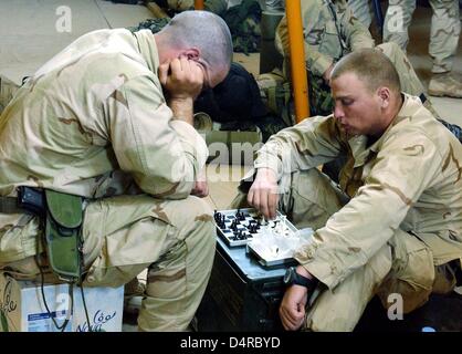 US Marines armés sont en jouant aux échecs, le 13 mars 2003, au Camp Coyote au Koweït. Plus de 150 000 soldats américains et britanniques sont actuellement situés dans le désert du nord du Koweït. Selon le département américain de la Défense, les soldats pourraient lancer une attaque contre l'Irak à tout moment. Banque D'Images