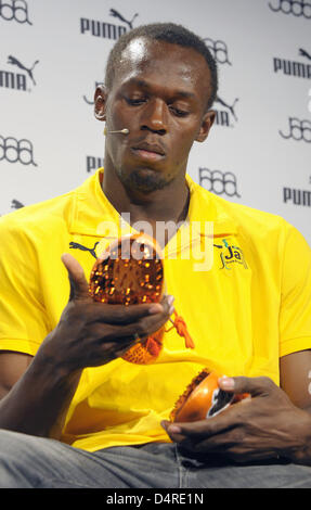 Le sprinter jamaïcain Usain Bolt pose avec une chaussure de course lors d'une conférence de presse sur le prochain championnat du monde d'athlétisme IAAF à Berlin, Allemagne, 13 août 2009. Plans vis pour gagner le 100m sprint et final de détrôner le tenant du titre Gay. Photo : SOEREN STACHE Banque D'Images