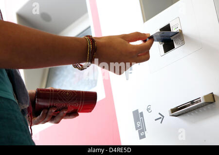 Une jeune femme se sert de sa carte de paiement pour payer son billet à un distributeur de billets à la gare Altona à Hambourg, Allemagne, 01 août 2009. Photo : Bodo Marks Banque D'Images