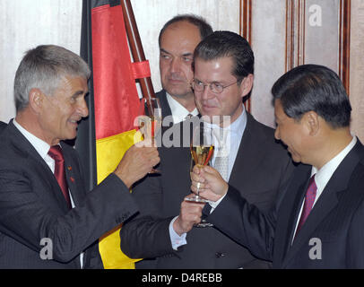 Karl-Theodor zu Guttenberg (2-R), le ministre allemand de l'économie, Vice-président chinois Xi Jinping (R) et Jürgen Hambrecht (L), Président de la Commission Asie-Pacifique de l'Allemagne ?s Business Association, clink lunettes à l'hôtel Adlon à Berlin, Allemagne, 12 octobre 2009. Le ministère chinois du commerce et le ministère allemand des Finances a signé un accord bilatéral sur l'échange de codes et de règles. Banque D'Images