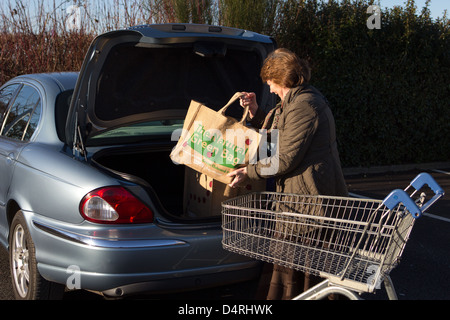 Journée dans la vie de femme, en voiture avec shopping chargement re Utilisez des sacs, après le magasinage à Tesco UK Banque D'Images