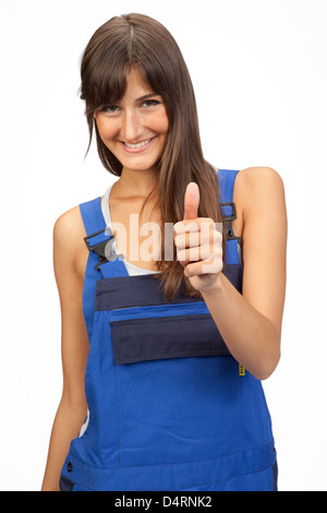 Jeune femme avec de longs cheveux bruns dans un boiler suit salopette Thumbs up Banque D'Images