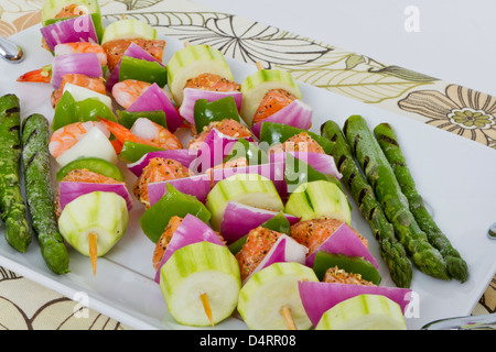 Cubes de saumon et de crevettes a complimenté avec légumes sur les brochettes. Prêt à cuire. Courgettes, oignons rouges, poivrons et asparagu Banque D'Images